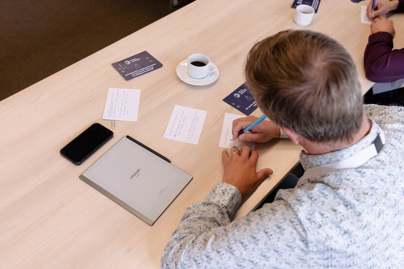 Bijeenkomst RTTI NTM, deelnemers tijdens de werksessies die informatie opschrijft